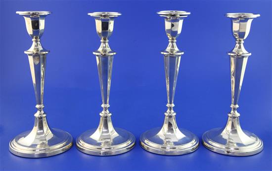 A set of four Edwardian silver candlesticks, weighted.